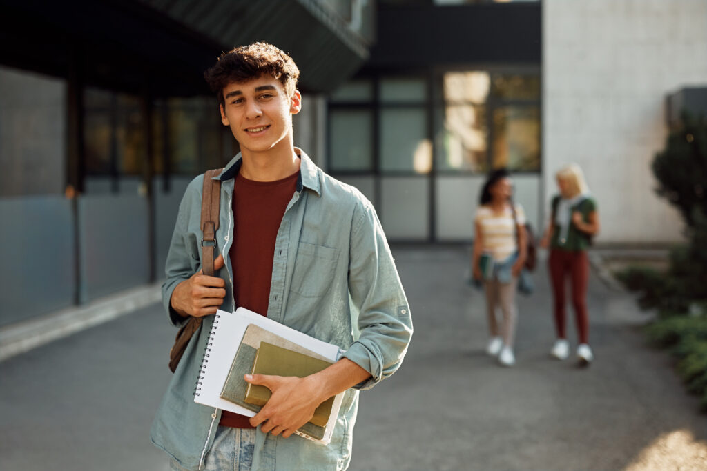 portrait of male college student at campus looking at camera.